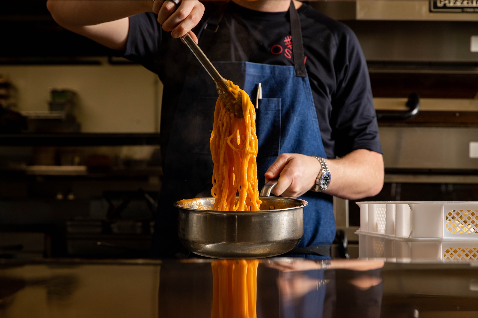 Chef preparing pasta in Ospi Venice kitchen